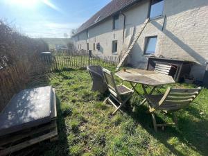 a table and chairs in a yard next to a house at Petit duplex cosy coup de coeur, dans ferme de charme du 18 è siècle au milieu des champs in Bossut-Gottechain