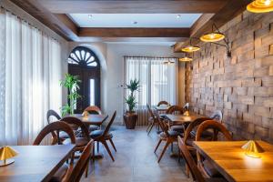 a restaurant with wooden tables and chairs and a brick wall at Arctic Boutique Hotel in Korçë