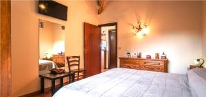 a bedroom with a bed and a dresser and a desk at Villa Giardino Aloe - Rifugio nella Natura Siciliana, Lontano dal Caos di Taormina in Castelmola