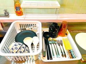 a white dish basket with utensils in a sink at Hotel Plum in Dazaifu