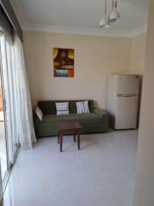 a living room with a green couch and a refrigerator at jo sunny lakes in Sharm El Sheikh