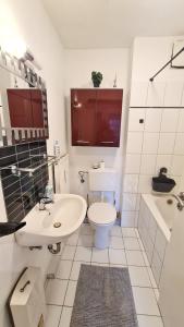 a white bathroom with a toilet and a sink at Simple Stay Pulheim in Pulheim