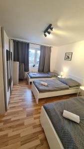 two beds in a room with wooden floors at Simple Stay Pulheim in Pulheim