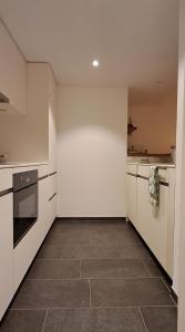 a kitchen with white cabinets and a tile floor at Helvetia 2005 Sr 2-ZW 2 Stock in Lenzerheide
