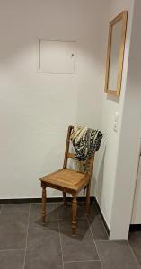 a wooden chair sitting in a room with a mirror at Helvetia 2005 Sr 2-ZW 2 Stock in Lenzerheide +3 photos