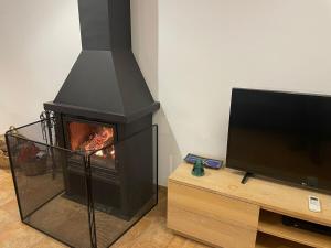 a living room with a fireplace and a tv at Ulldemolins Niuet in Ulldemolins