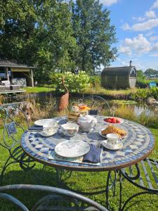 a picnic table with food on it with a bird in the background at Wellnessloft A Winters Tale in Dieverbrug