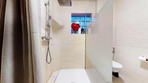 a bathroom with a shower with a heart on the wall at Suite climatisée, 2 personnes in Montry +8 photos