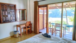 a bedroom with a bed and a table and a balcony at Meexok guesthouse in Nongkhiaw