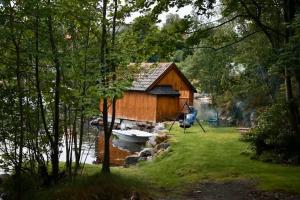 a house on the water with a boat in it at Apartment with exceptional view in Ålesund