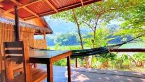 a hammock on the porch of a tree house at Meexok guesthouse in Nongkhiaw