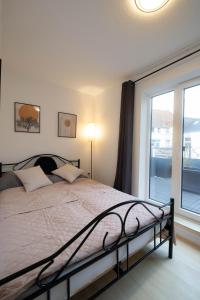 Un dormitorio con una cama y una ventana grande. en Bismarck Home - Central and Relaxing with Rooftop Terrace in Essen, en Essen