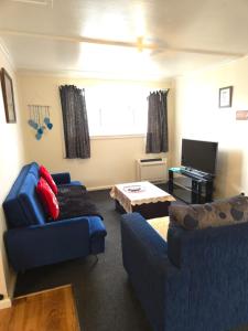 a living room with two couches and a tv at Glacier house in Fox Glacier