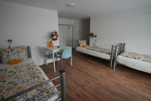 a room with three beds and a table and a desk at Center Hostel and Guest House in Budapest