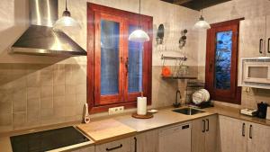 a kitchen with a sink and a stove top oven at La Casa de Sofía in Navaconcejo +12 photos