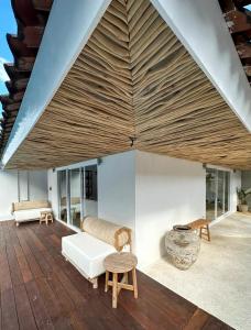 a living room with a wooden floor and a wooden ceiling at Luxury at Family Ties Villa in Gili Air