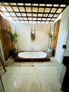 a bathroom with a bath tub in a room at Luxury at Family Ties Villa in Gili Air