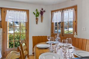 Un comedor con una mesa con copas de vino. en Chalet spacieux dans le Val Ferret, en Orsières