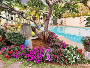 a statue in a flower garden next to a swimming pool at Villa 1 , Phường 2 ngay trung tâm thành phố bảo lộc in Bao Loc
