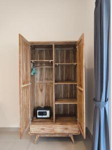 a wooden book shelf with a radio in it at Kubu Shankara Homestay in Uluwatu
