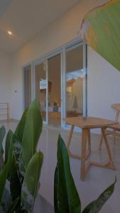 a room with a wooden table and a window at Kubu Shankara Homestay in Uluwatu