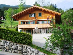a house in the mountains with a stone wall at Delightful 4star Chalet Kiwi Apt in Grindelwald
