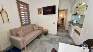 a living room with a couch and a kitchen at Michele Marie apts in Agia Pelagia
