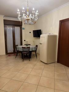 a dining room with a table and a refrigerator at Locazione Turistica Fusillo Lorusso con parcheggio privato in loco in Barletta