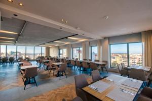 a dining room with tables and chairs and windows at ADAY Hotel Casablanca in Casablanca