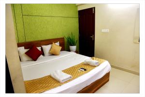 a bedroom with a bed with towels on it at Aliyans Residency in Cochin