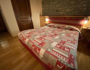 una camera da letto con un letto con una trapunta natalizia sopra di Chambres D'hôtes Maribel a Pré-Saint-Didier