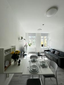 a white living room with a table and a couch at Modernes Apartment am Marienplatz, Schwerin in Schwerin