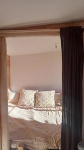 a bed with pillows on it in a bedroom at Original tiny in Aspet