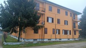 an orange building with a tree in front of it at cristina in Pavia