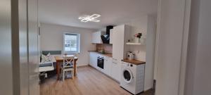 a kitchen with a washer and dryer and a table at gemütliche Ferienwohnung Achteltal in Simmelsdorf