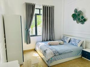 a bedroom with a bed with a mirror and a window at Villa 3 , Phường2 Ngay trung tâm thành phố bảo lộc in Bao Loc