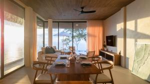 a living room with a wooden table and chairs at Amor Kohtao in Ko Tao