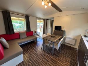a living room with a couch and a table at LES PIERRES CHAUDES in Veyrignac