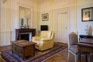 a living room with a chair and a fireplace at Château de Sissi in Sassetot-le-Mauconduit