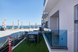 a balcony with a table and chairs and the ocean at Blue Balcony Boutique Beachfront Suite with Private Parking in Chania Town