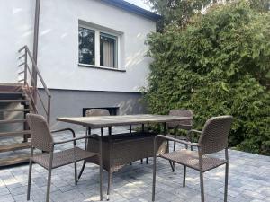 a table and chairs on a patio with a fireplace at Dom na Zdrowiu in Łódź
