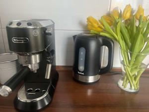 a coffee maker and a vase with flowers on a table at Dom na Zdrowiu in Łódź +5 photos
