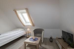 a living room with a couch and a tv at An der Düne 2, Whg 3 in Hörnum