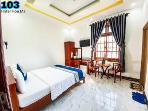 a bedroom with a bed and a table and a window at Hotel Hoa Mai in Con Dao