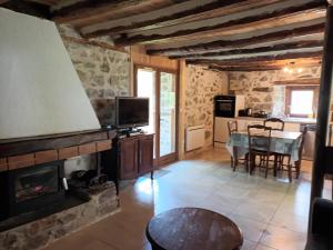 a living room with a fireplace and a table at Bergerie Macha in Ustou
