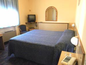 Odec Hotel في ألتوباشو: غرفة فندق بها سرير وهاتف