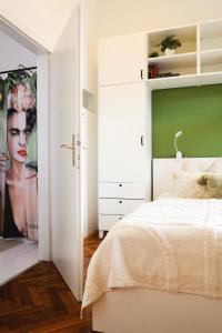 Un dormitorio con una cama blanca y una pared verde. en Zentrales und stilvolles Apartment mit Schlossbergblick und Parkplatz, en Graz