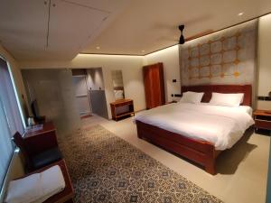 a large bedroom with a large bed and a chair at kmslegacy in Jāmb +29 photos