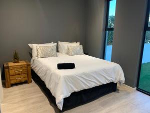 a bedroom with a bed with a black pillow on it at B&B Sitari County Estate - The Most Iconic Estate in Cape Town