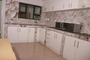 a kitchen with white cabinets and a microwave at Gift Guest house 3 in Cravenby